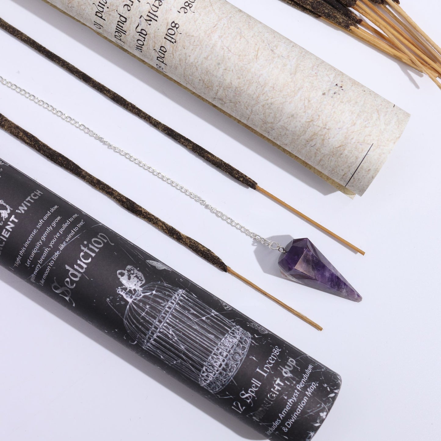Ancient Witch Spell Incense: Seduction with amethyst pendulum pendant on a silver chain beside rolled parchment.